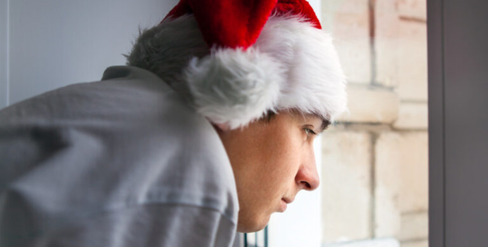 Person with a festive hat on looking out of the window.