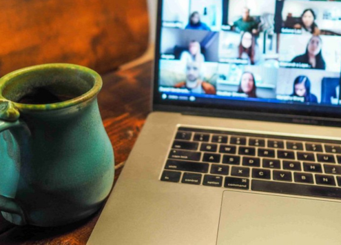 Image displaying a cup of coffee and a laptop with a zoom session in progress