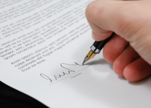 Person signing their name on an official document.