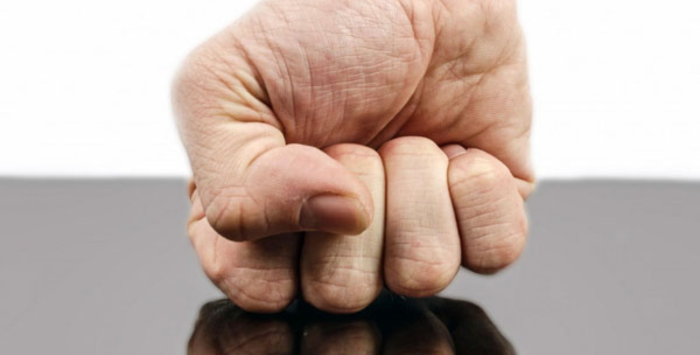 Clenched fist hitting a surface