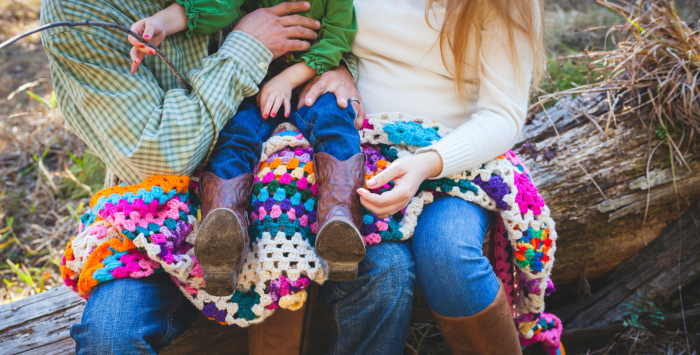 Family sat outdoors with blanket